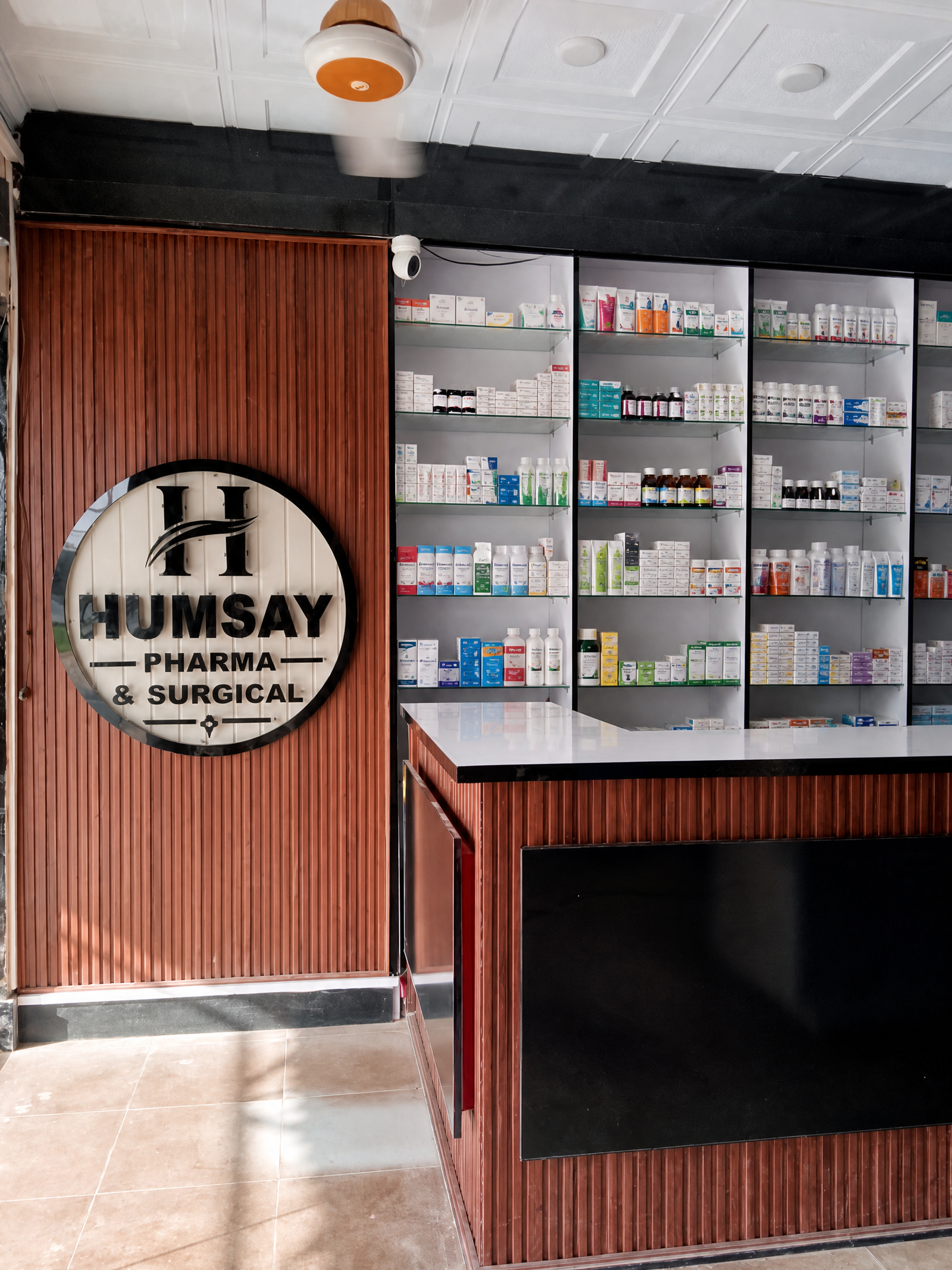 Humsay Pharmacy medicine shelves and logo